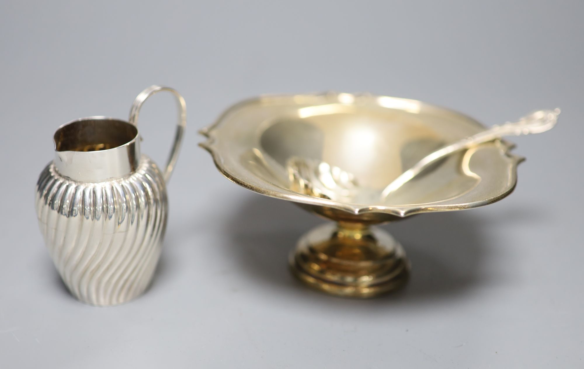 A silver shaped square small pedestal bowl, a silver spiral-fluted cream jug and a silver sifter spoon, gross 5.18oz.
